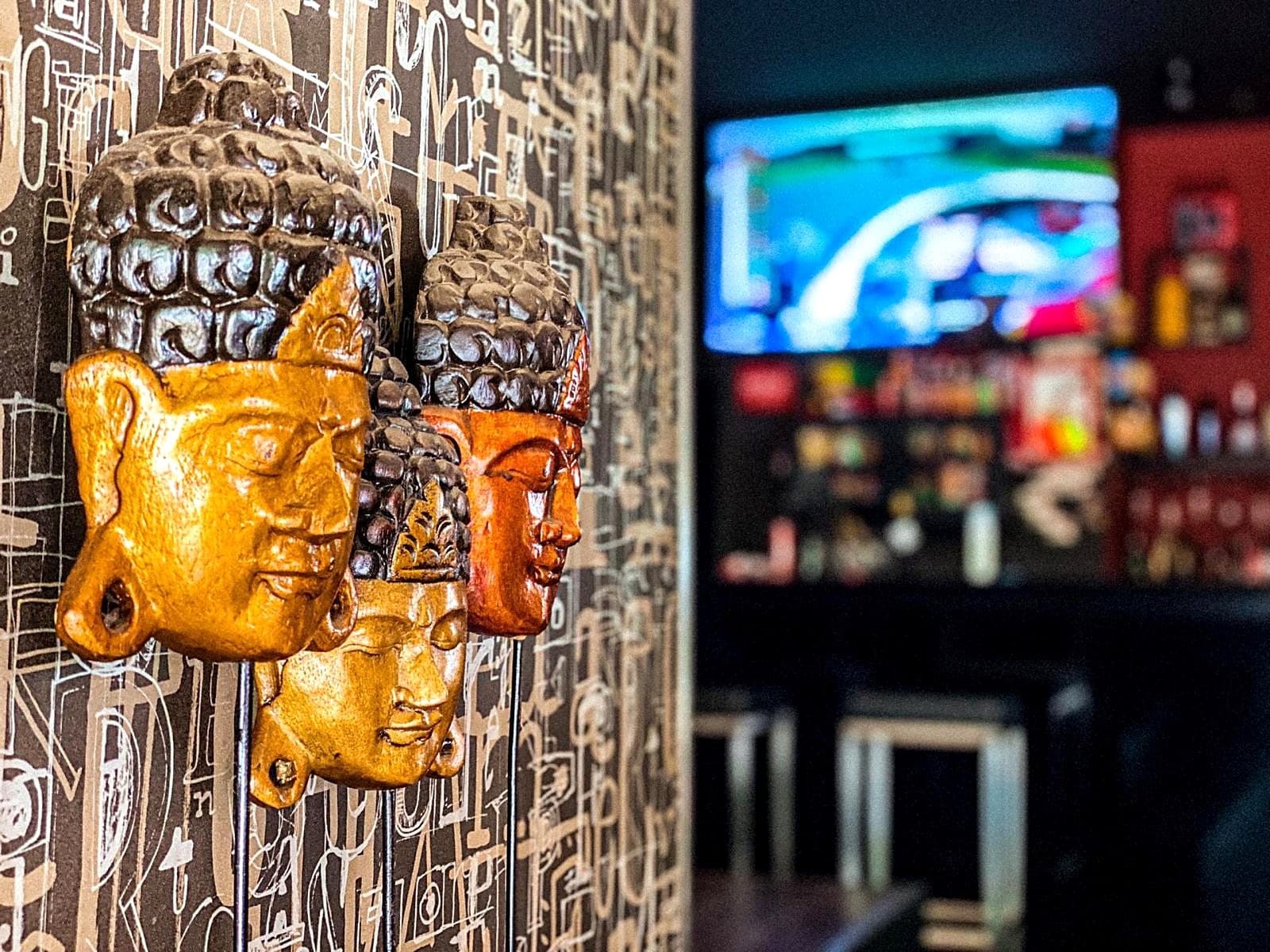 Máscaras douradas na parede e televisão com desporto ao fundo
