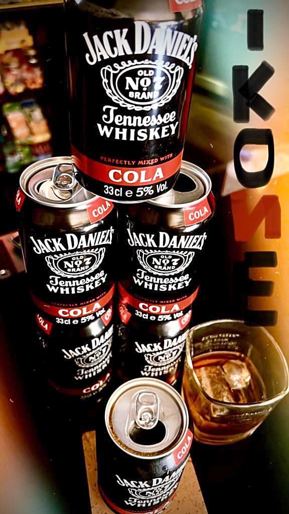 Latas de Jack Daniel's & Cola e um copo com gelo